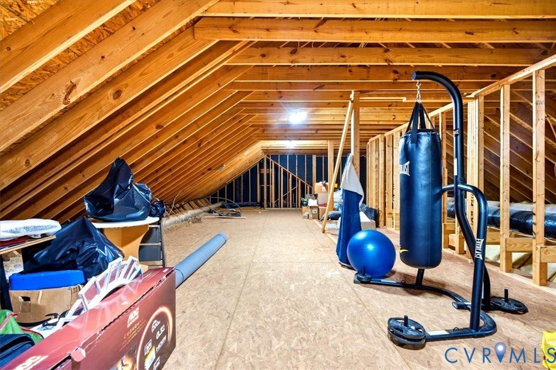 Open attic space with exposed wood framing and particle board flooring