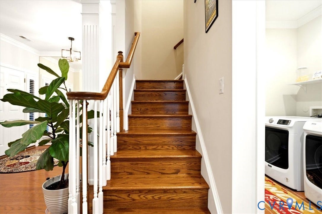 Hardwood staircase with white balusters and wood handrail