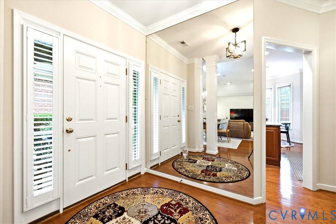 Entryway featuring a white paneled front door with sidelights, crown molding, and wood-finish flooring
