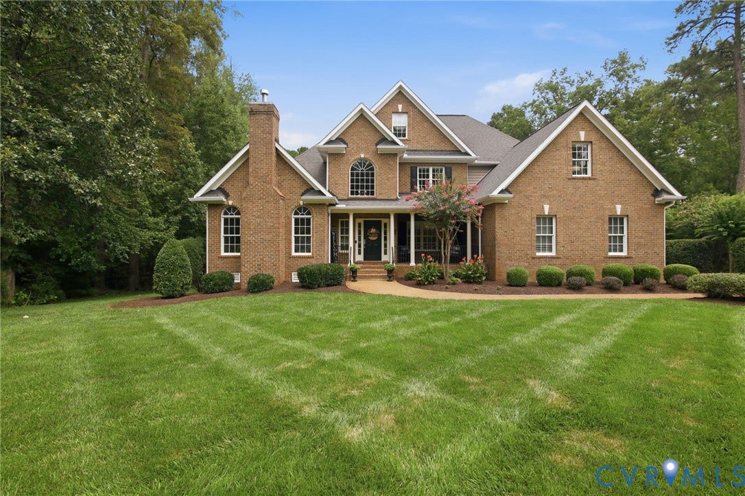 435 Shadow Creek Lane, Manakin Sabot, VA 23103 Traditional brick residence featuring a prominent front gable, multiple window dormers, and a covered entry porch