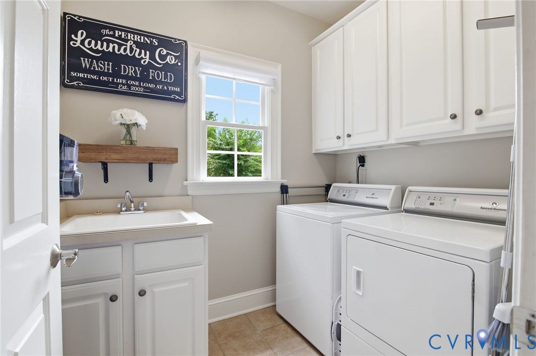 435 Shadow Creek Lane, Manakin Sabot, VA 23103 Dedicated laundry space featuring white cabinetry, a utility sink with a base cabinet, and a window providing natural light