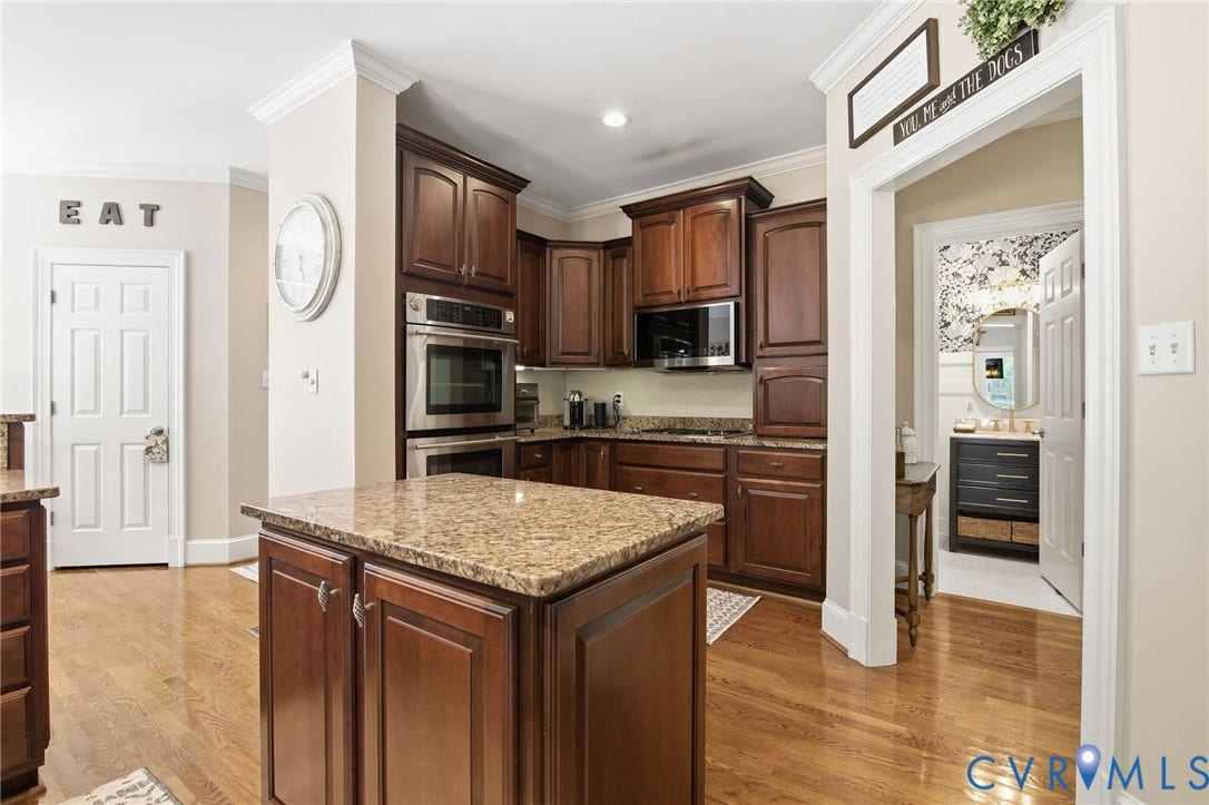 435 Shadow Creek Lane, Manakin Sabot, VA 23103 Kitchen featuring a central island with a granite countertop, wood-finish flooring, dark wood cabinetry, and stainless steel double ovens
