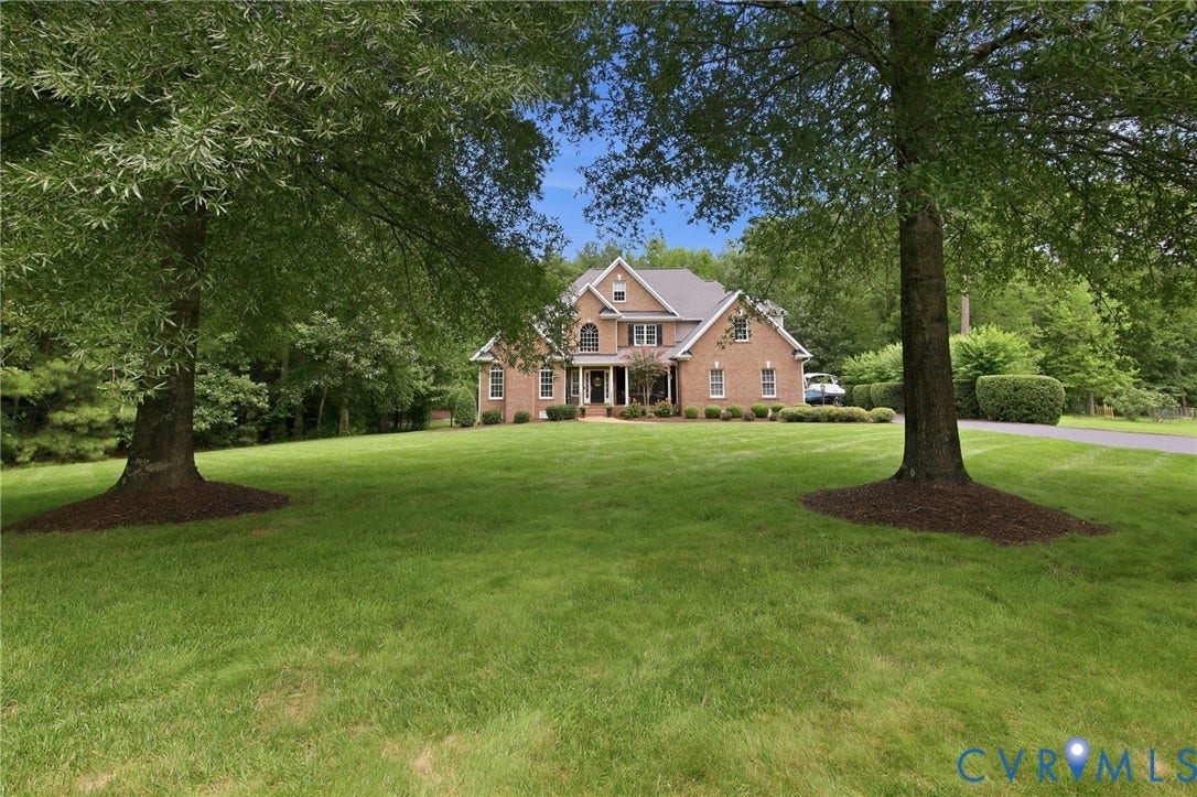 435 Shadow Creek Lane, Manakin Sabot, VA 23103 Brick exterior residence set back on a spacious green lawn with mature trees framing the property