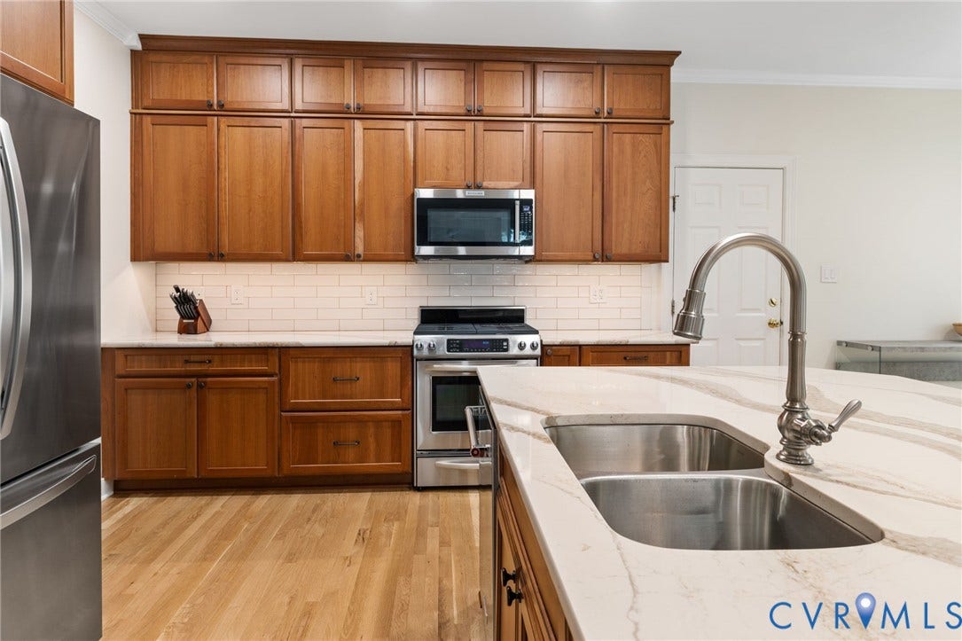 12305 Bradford Landing Way, Wyndham, Glen Allen, VA 23059 Kitchen featuring wood cabinetry, stainless steel appliances, a subway tile backsplash, and Quartz countertops