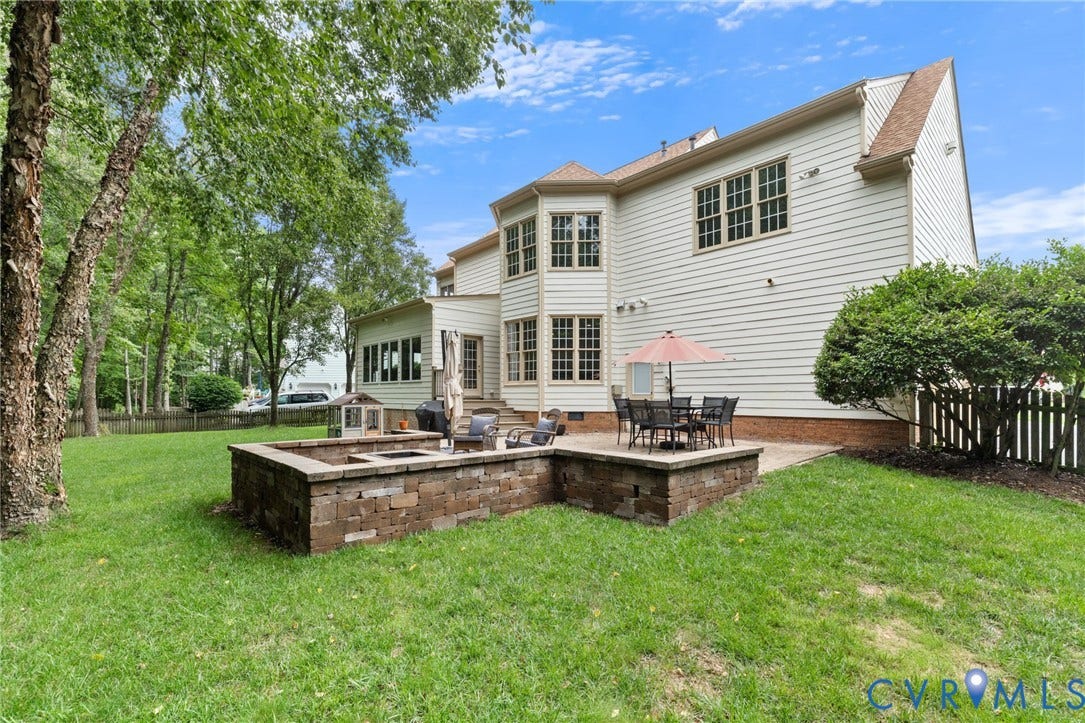 12305 Bradford Landing Way, Wyndham, Glen Allen, VA 23059 Expansive backyard with a stone-clad fire pit, concrete patio, and mature trees