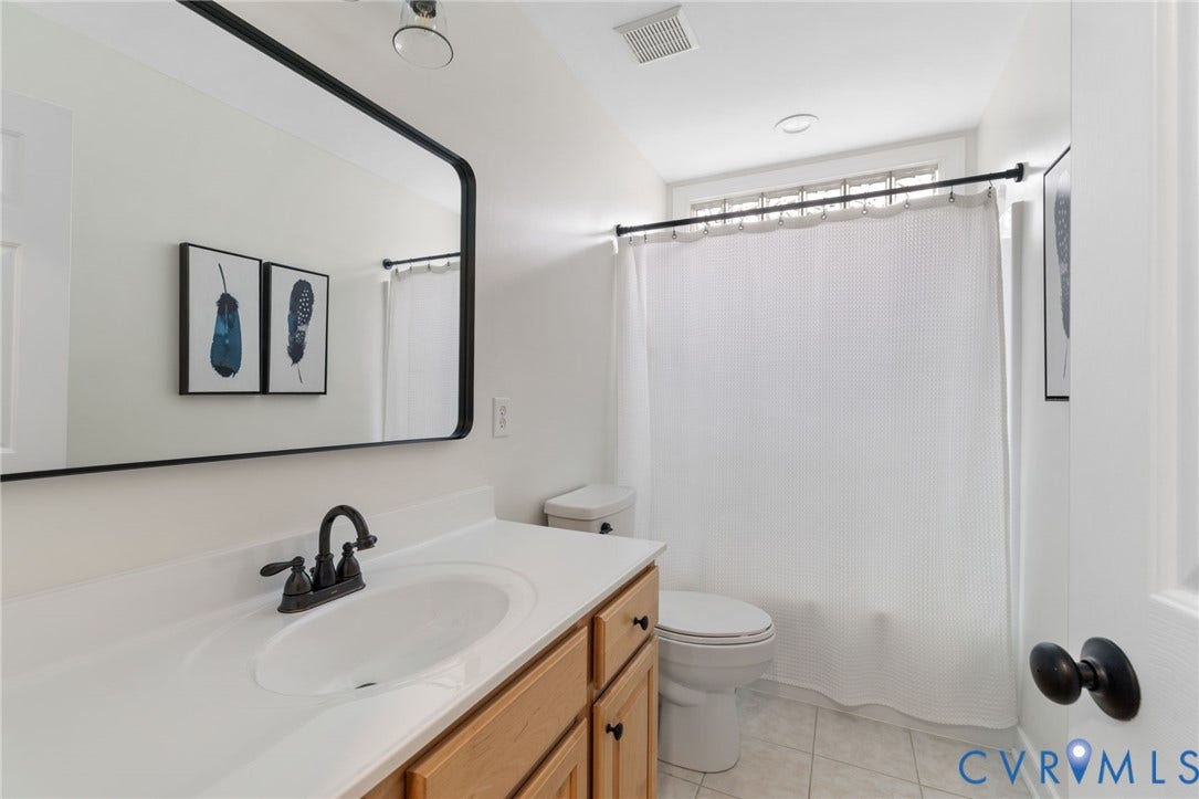 12305 Bradford Landing Way, Wyndham, Glen Allen, VA 23059 Hall Bathroom featuring a wood-finish vanity with a white countertop and integrated sink, matte black faucet, and rectangular mirror