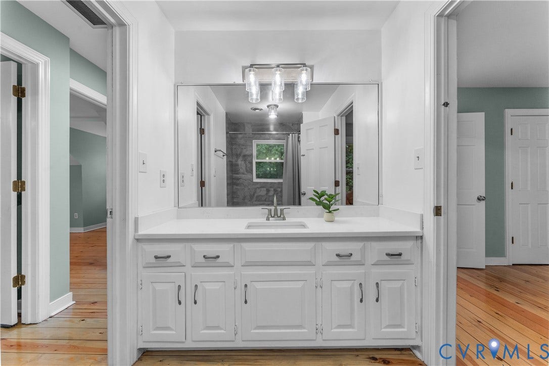 3927 Hughes Creek Road, Powhatan, VA 23139 White vanity with ample storage, a single basin, and a wall-mounted light fixture