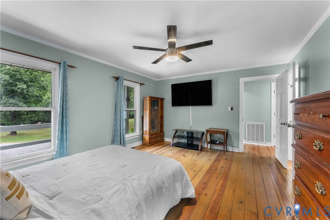 3927 Hughes Creek Road, Powhatan, VA 23139 Hardwood flooring, two large windows, white trim, crown molding, and a ceiling fan with integrated lighting