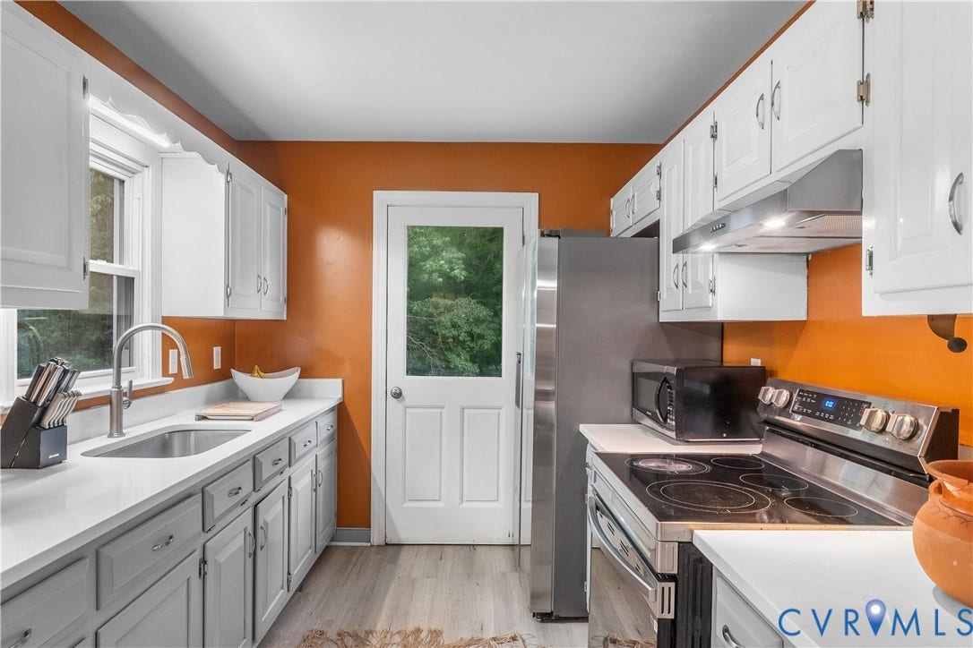 3927 Hughes Creek Road, Powhatan, VA 23139 White cabinetry with silver hardware, light-toned countertops, stainless steel appliances, and wood-finish flooring