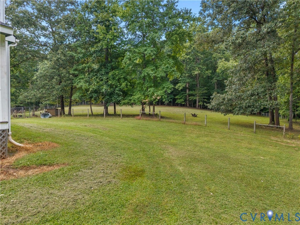 3927 Hughes Creek Road, Powhatan, VA 23139 Expansive grassy lawn bordered by mature trees and a partial fence