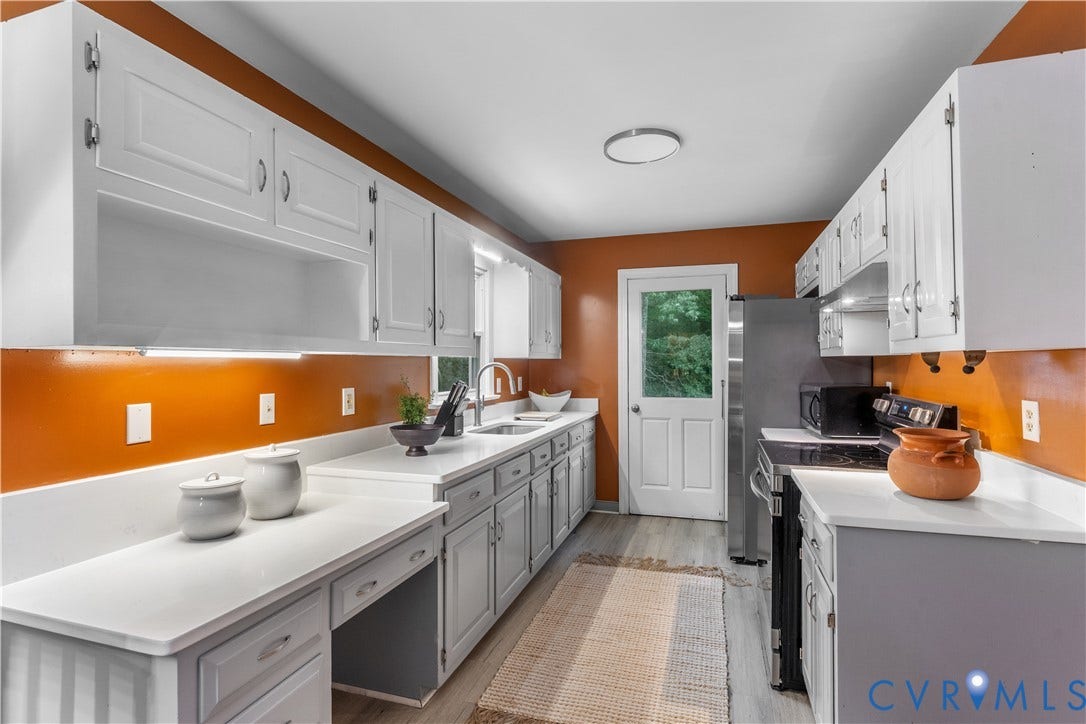 3927 Hughes Creek Road, Powhatan, VA 23139 White cabinetry with under-cabinet lighting, light-toned countertops, stainless steel refrigerator, stainless steel range, and wood-finish flooring