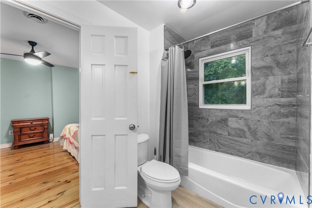 3927 Hughes Creek Road, Powhatan, VA 23139 Bathtub with a single window, gray-toned tile surround, and a ceiling-mounted light fixture