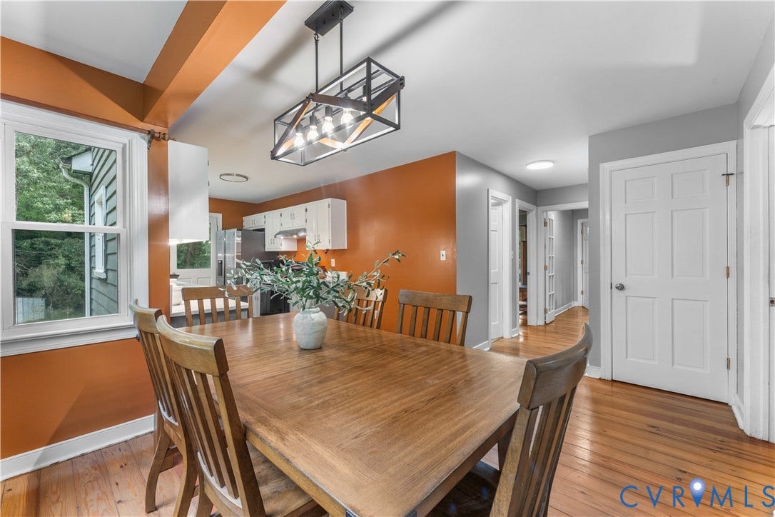 3927 Hughes Creek Road, Powhatan, VA 23139 Warm dining area featuring wood-finish flooring, a modern linear chandelier, and a bright window