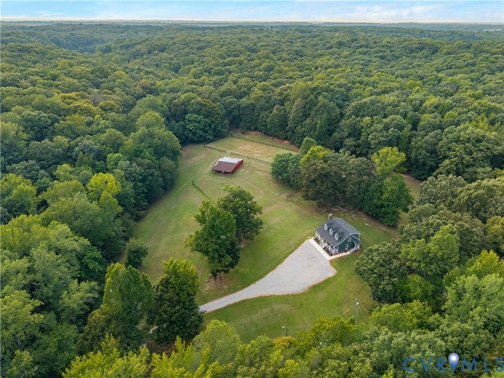 3927 Hughes Creek Road, Powhatan, VA 23139 Extensive wooded acreage featuring a main residence, gravel driveway, red barn, and fenced pasture