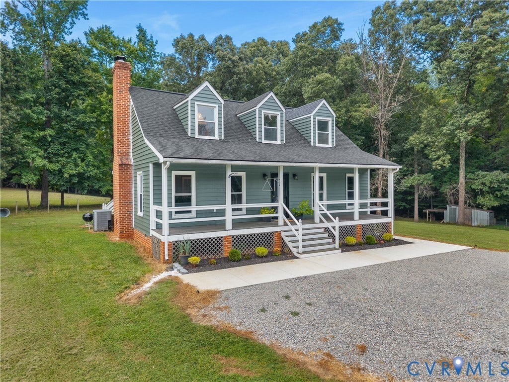 3927 Hughes Creek Road, Powhatan, VA 23139 Siding exterior with three dormer windows, a full-width front porch, a brick chimney, and a gravel driveway