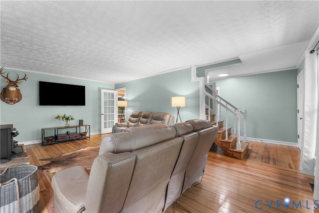 3927 Hughes Creek Road, Powhatan, VA 23139 Hardwood flooring, painted walls, white trim, and a white staircase with wood treads