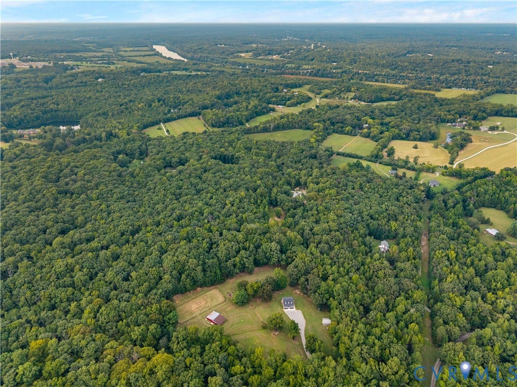 3927 Hughes Creek Road, Powhatan, VA 23139 Expansive wooded landscape featuring clearings, distant structures, and a serene water body