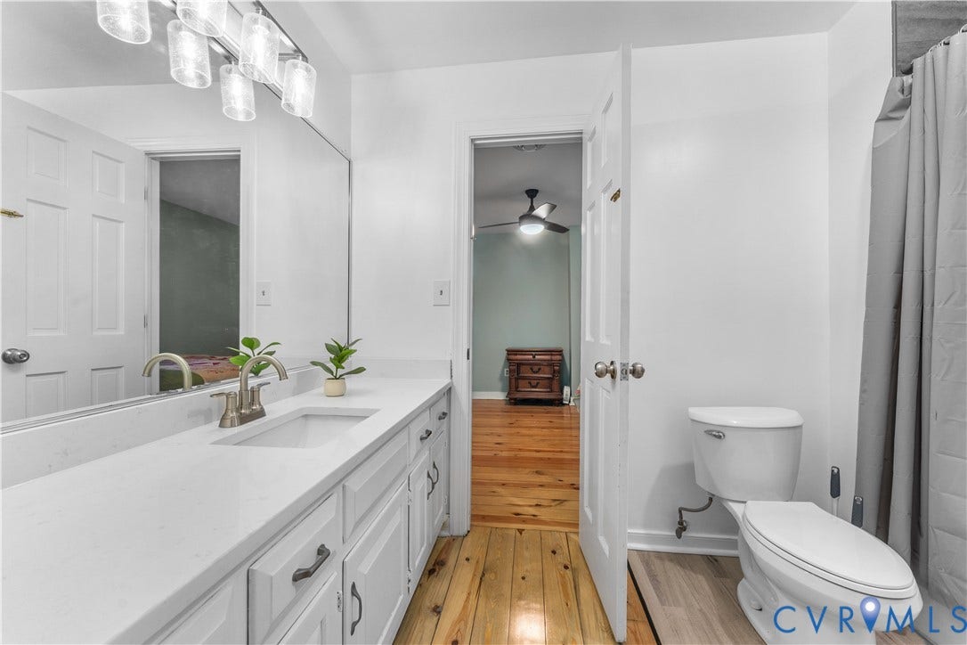 3927 Hughes Creek Road, Powhatan, VA 23139 White vanity with an integrated sink, brushed nickel faucet, large mirror, and overhead vanity lighting