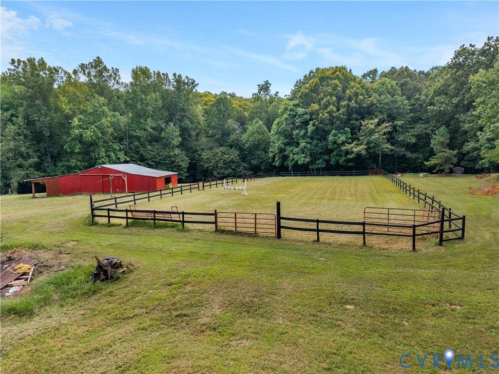 3927 Hughes Creek Road, Powhatan, VA 23139 Expansive fenced pasture with a red barn featuring an attached lean-to