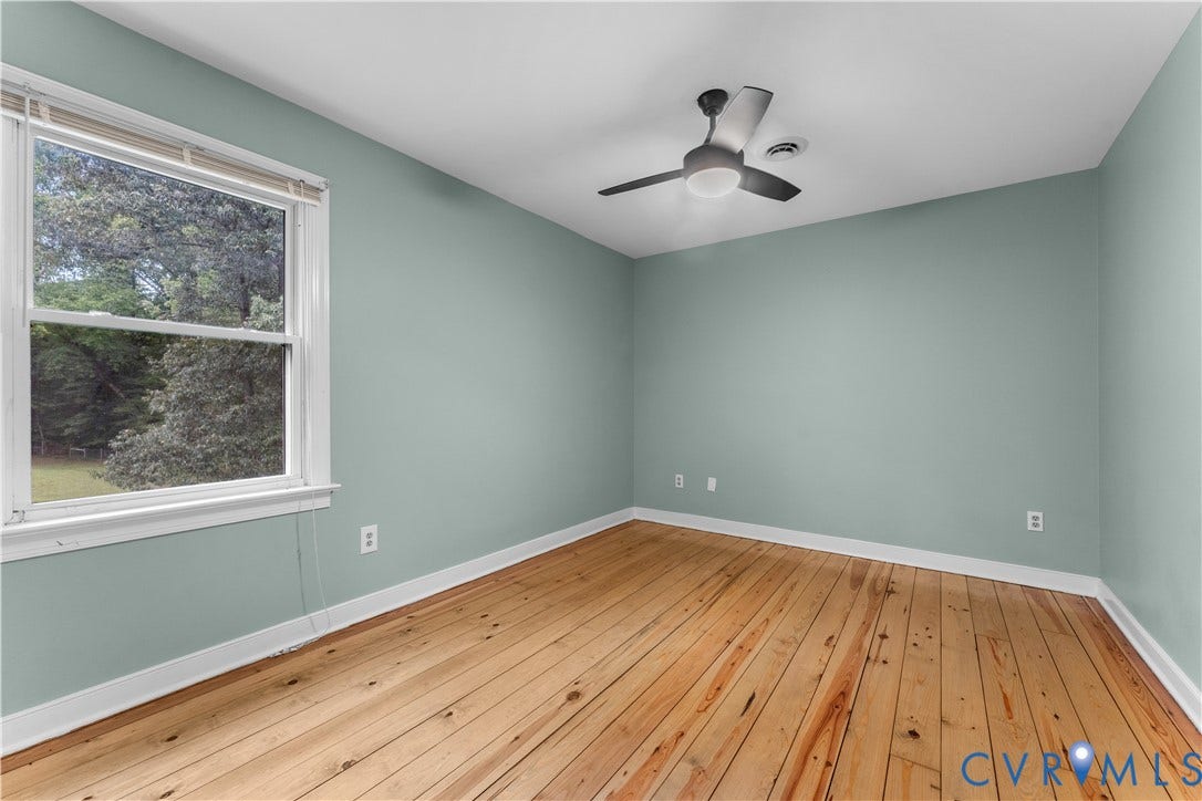 3927 Hughes Creek Road, Powhatan, VA 23139 Wood-finish flooring with light-toned walls, a white window frame, and a ceiling fan with integrated lighting