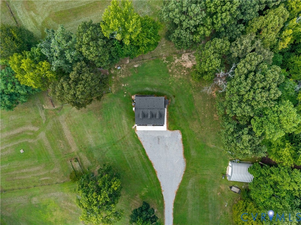 3927 Hughes Creek Road, Powhatan, VA 23139 Expansive green lawn with a gravel driveway, mature trees, a detached building, and an additional structure