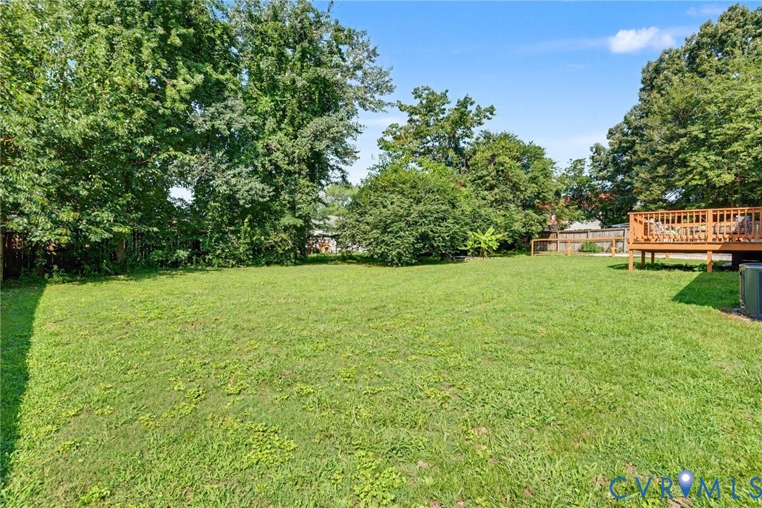 8906 Huntingcreek Place, Chesterfield, VA 23237 Expansive grassy yard with mature trees and a raised wood-finish deck