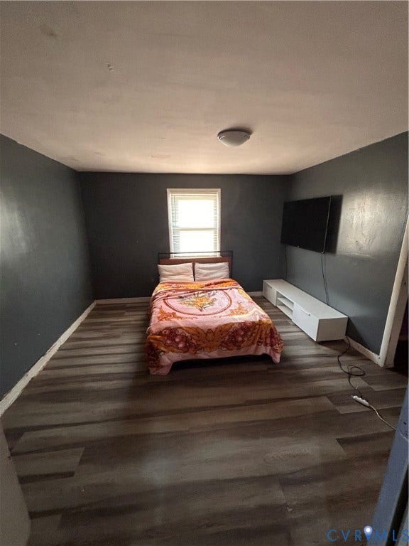 Room featuring wood-finish flooring, a window with natural light, and a ceiling-mounted light fixture