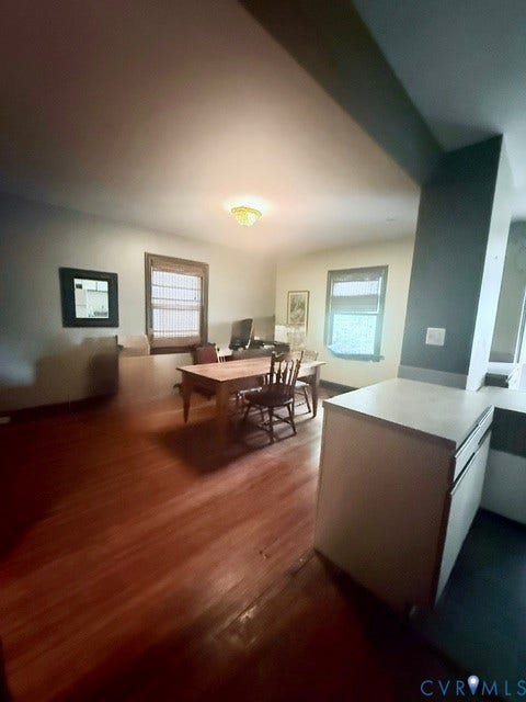 Expansive room featuring rich wood-finish flooring