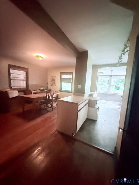 Hardwood flooring extends throughout the main living area, complemented by a ceiling light fixture and window treatments