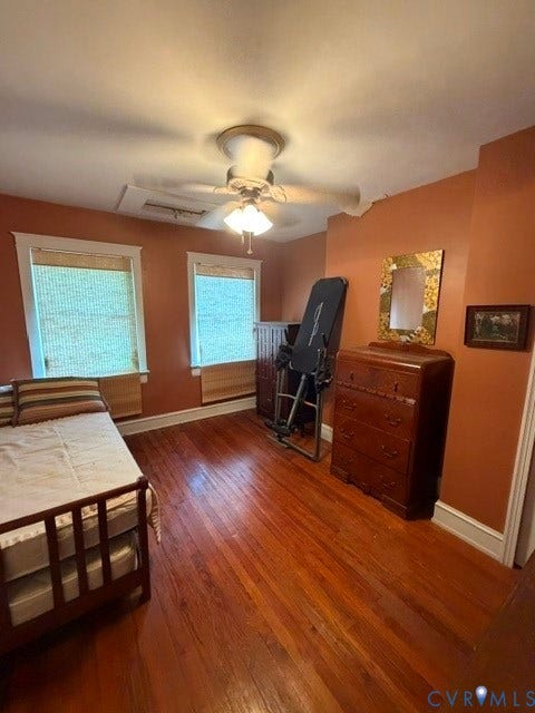 Hardwood flooring, two windows with blinds, ceiling fan with light fixture, and white trim