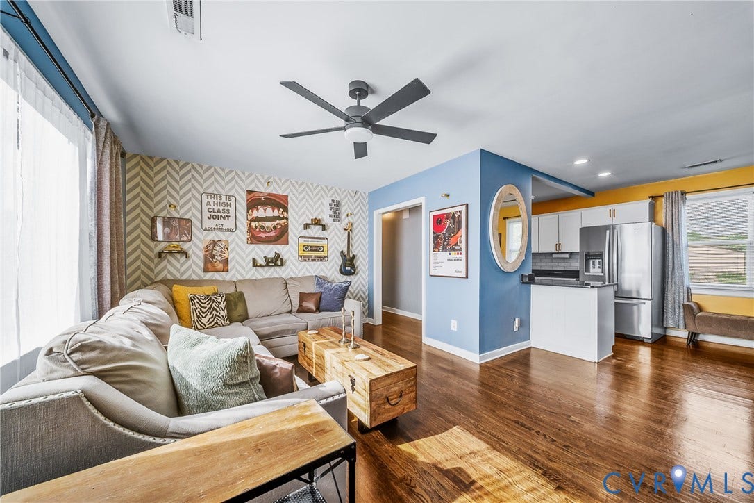 3304 Carlton Road, Henrico, VA 23223 Open-concept living space featuring wood flooring, a contemporary ceiling fan, and a kitchen area with white cabinetry and stainless steel appliances