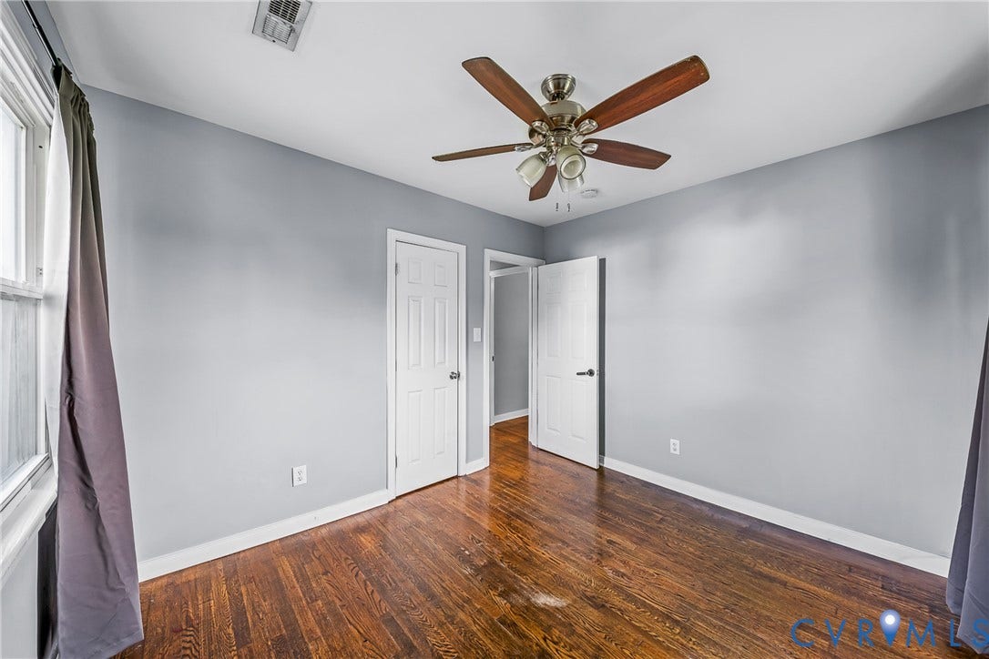 3304 Carlton Road, Henrico, VA 23223 #2 Interior room featuring wood flooring, light gray walls, a window with white trim, and a ceiling fan with integrated lighting