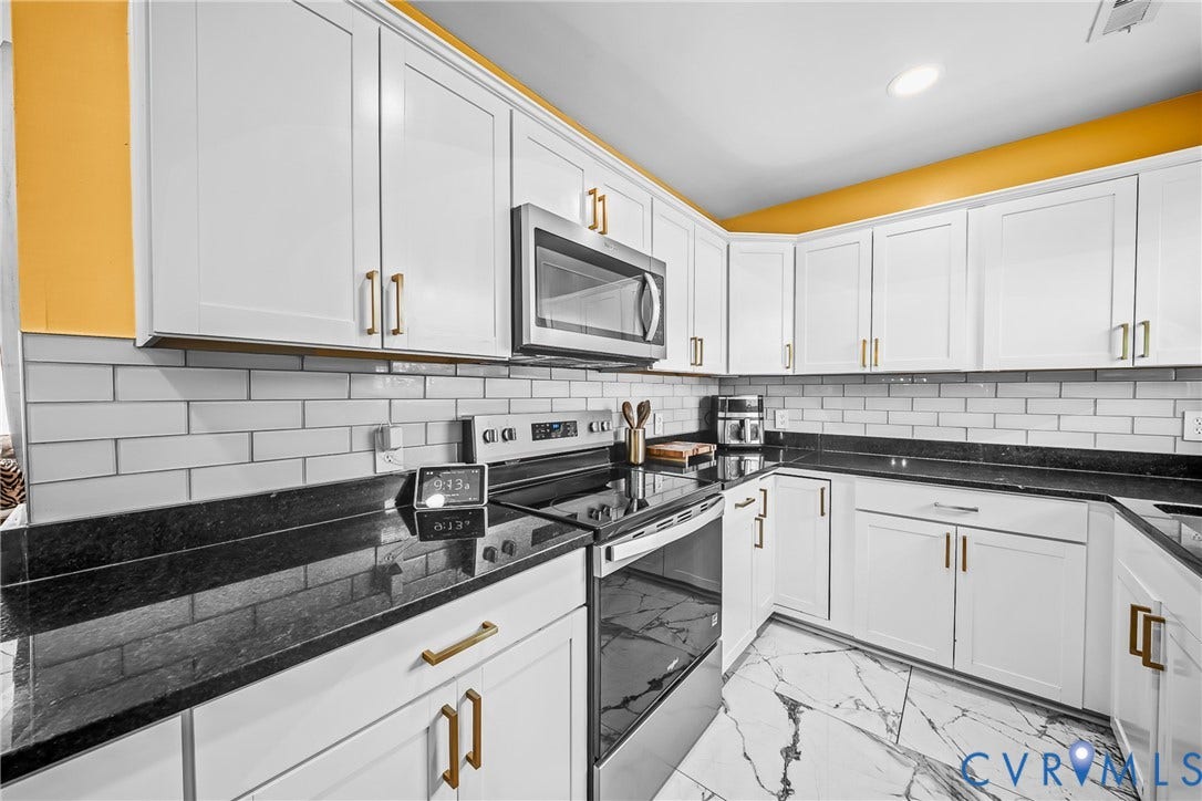 3304 Carlton Road, Henrico, VA 23223 Contemporary kitchen featuring white cabinetry with brass hardware, a white subway tile backsplash, and dark countertops