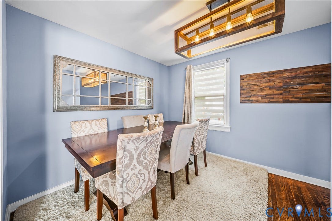 3304 Carlton Road, Henrico, VA 23223 Dining area featuring a contemporary wood-frame chandelier, a large decorative mirror, and a wood accent wall