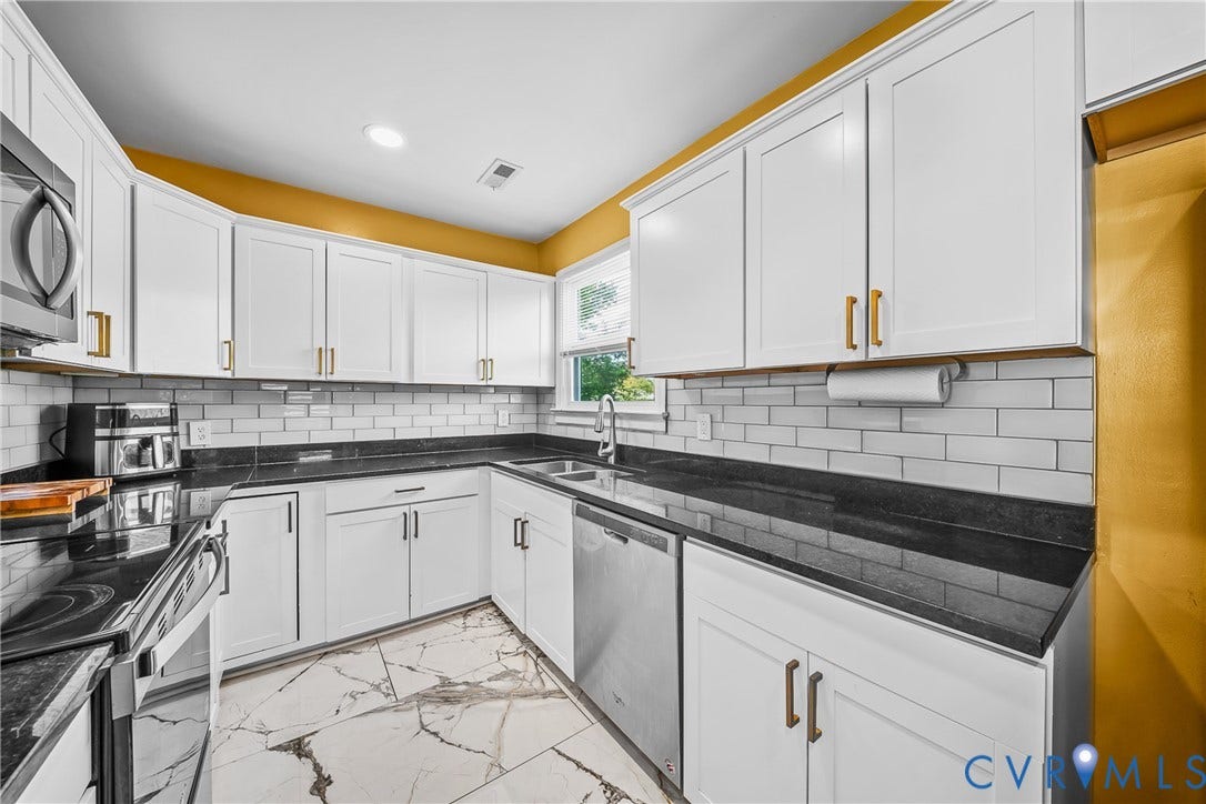 3304 Carlton Road, Henrico, VA 23223 Kitchen featuring white cabinetry with gold-finish hardware, black countertops, and a subway tile backsplash