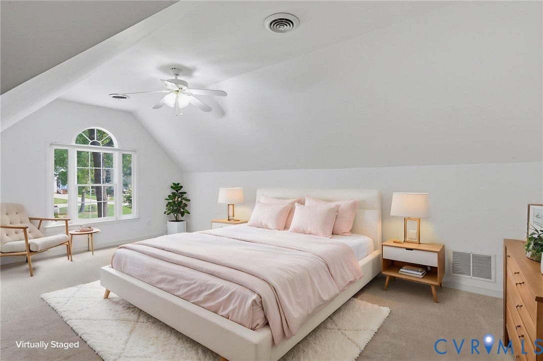 Bright room featuring an arched top window, sloped ceilings, a ceiling fan, and light-colored carpeting