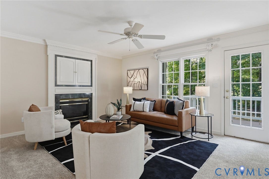 Living area featuring a fireplace with black stone surround, white mantel, and built-in cabinetry