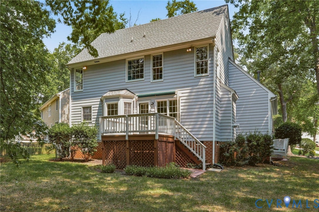 Rear exterior featuring light blue siding and a multi-level wood deck with white railings