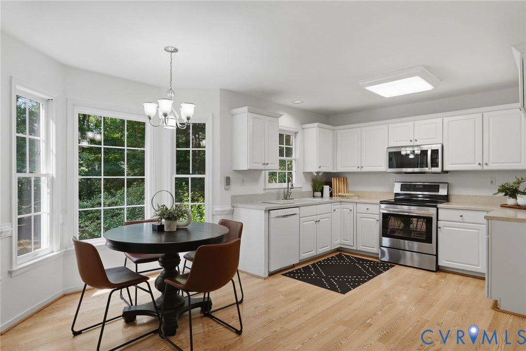 Kitchen featuring abundant white cabinetry, Corian countertops, and wood-finish flooring