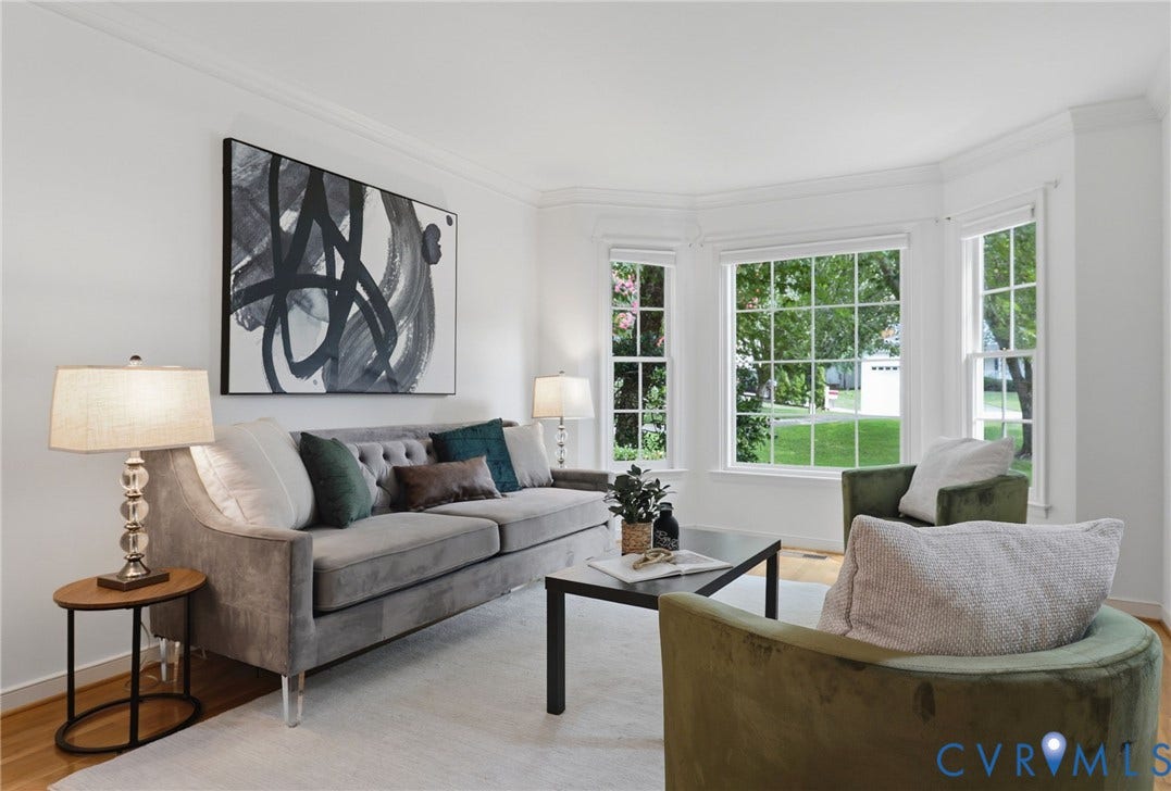 Bright living space featuring hardwood flooring and a large bay window