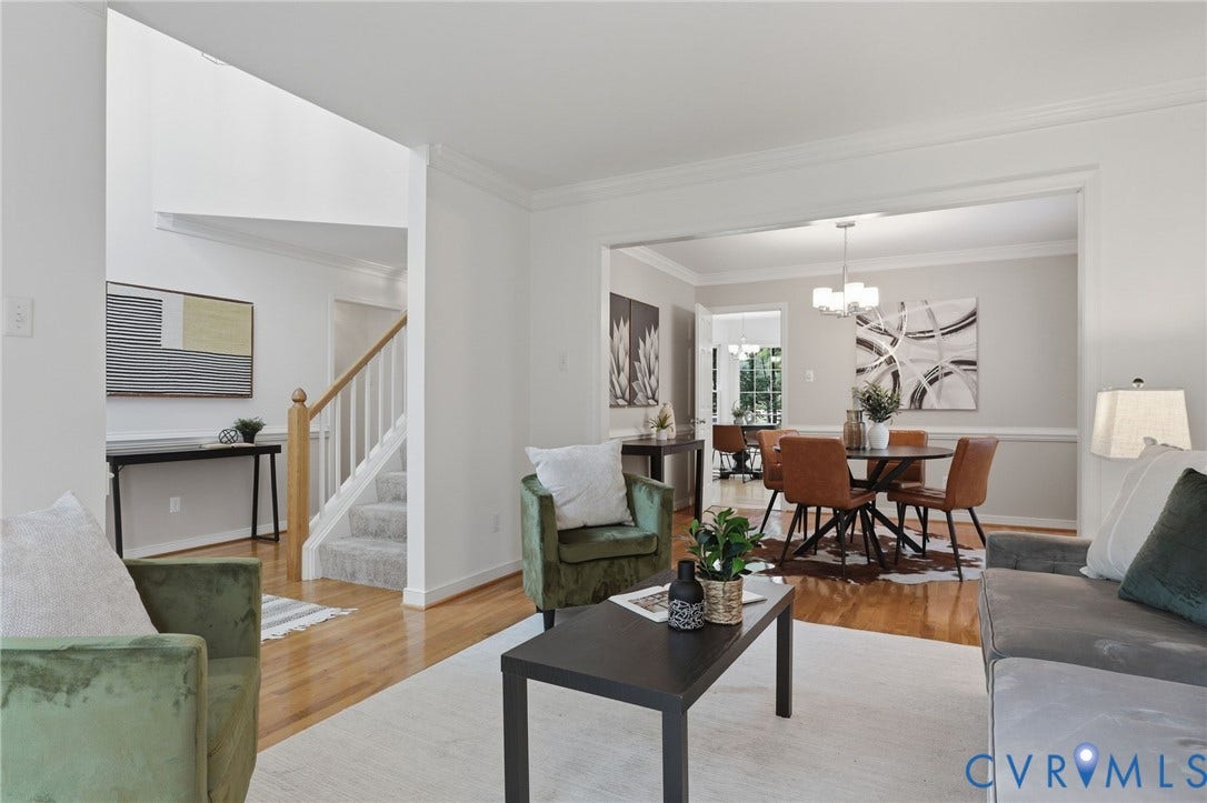 Hardwood flooring extends throughout the main level, complemented by white crown molding and chair rail detailing