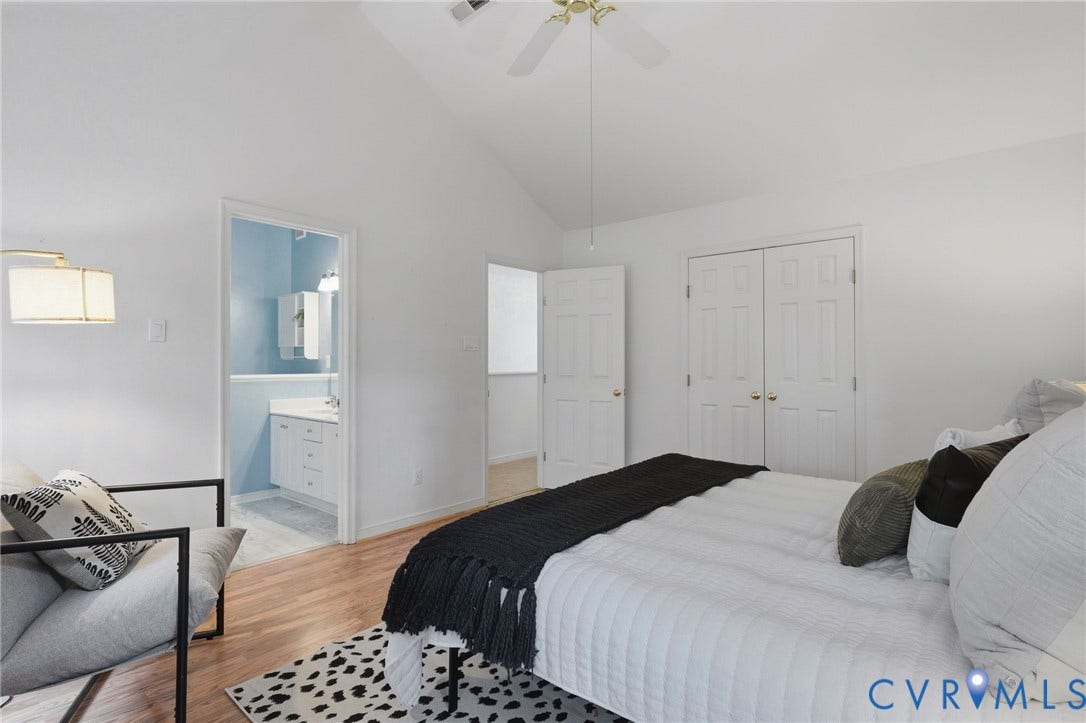 Vaulted ceiling bedroom featuring wood-finish flooring