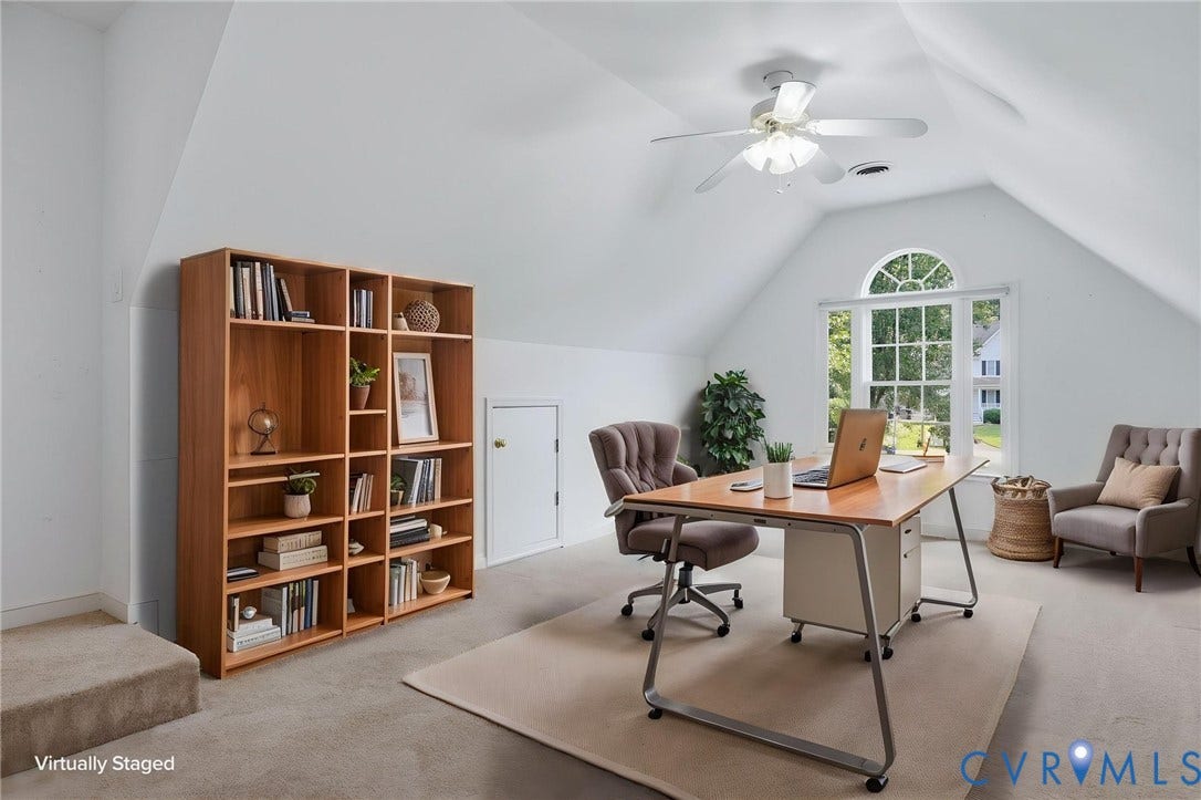 Vaulted ceiling room with an arched window, carpeted flooring, built-in shelving, and a ceiling fan