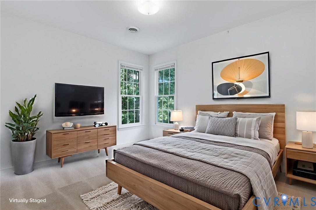 Carpeted bedroom featuring white walls, two double-hung windows, and a ceiling-mounted light fixture