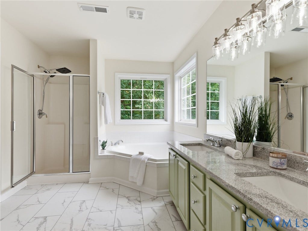 5707 Stephens Point Court, Chesterfield, VA 23831 Primary Bath featuring a corner soaking tub with two large windows, updated flooring, newly installed granite on double vanity sinks and a glass-enclosed shower.