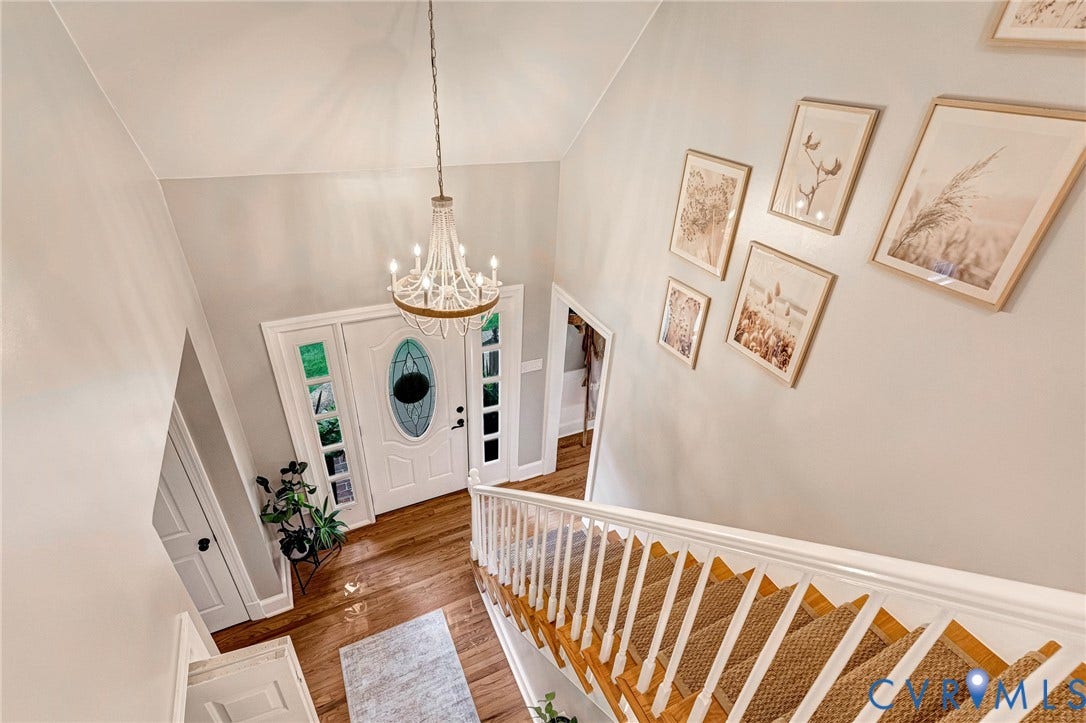 8800 Shewsbury Drive, New Kent, VA 23124 Two-story entryway featuring wood-finish flooring, a decorative chandelier, and an oval glass-paneled front door with sidelights
