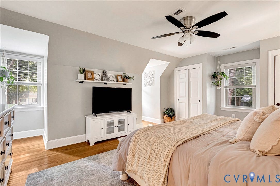 8800 Shewsbury Drive, New Kent, VA 23124 Attic bedroom featuring pitched ceilings, wood-finish flooring, two windows with blinds, a ceiling fan with light fixture, and white bi-fold closet doors