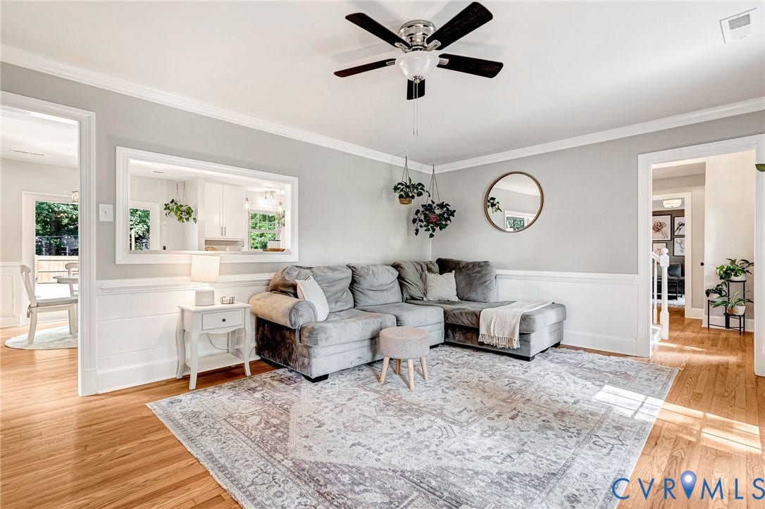 8800 Shewsbury Drive, New Kent, VA 23124 Living area featuring wood-finish flooring, white wainscoting, and crown molding