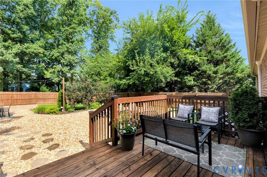 8800 Shewsbury Drive, New Kent, VA 23124 Spacious wooden deck with natural wood railing, extending to a gravel patio area