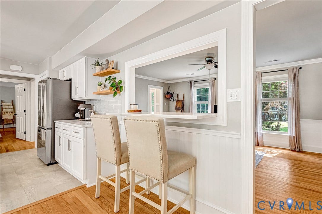 8800 Shewsbury Drive, New Kent, VA 23124 Kitchen with white shaker cabinetry, stainless steel appliances, light subway tile backsplash, and a pass-through window with a breakfast bar